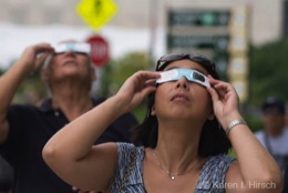 Woman with eclipse glasses looking up